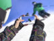 Person filming skiier on their mobile phone