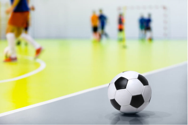Children playing futsal indoors